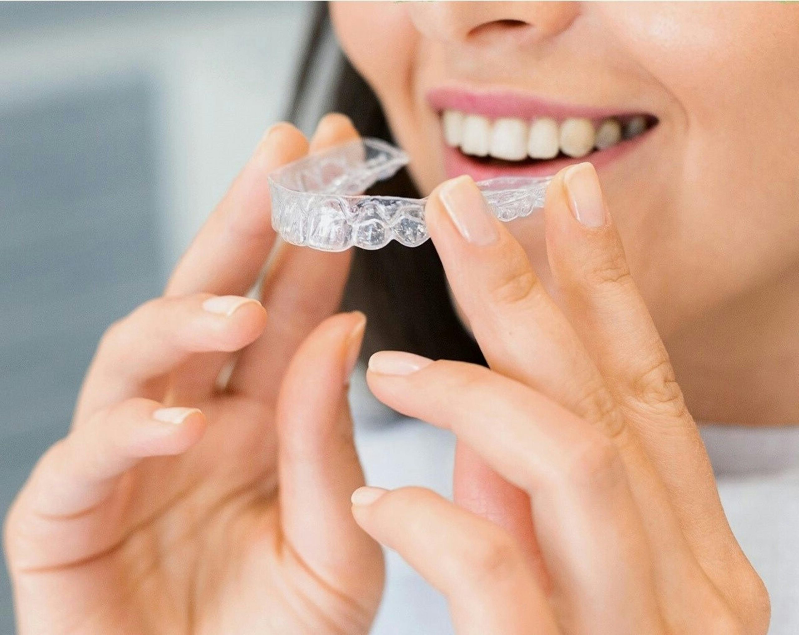 Clínica Odontológica Amorós - Torredembarra 2 mujer poniéndose unos invisalign con sus manos